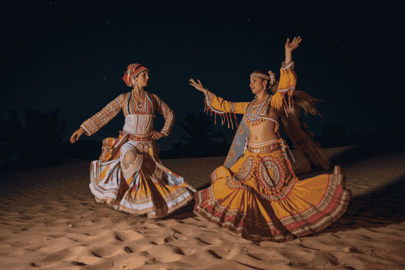 Enjoy live cultural dance performances during an evening desert safari in Abu Dhabi